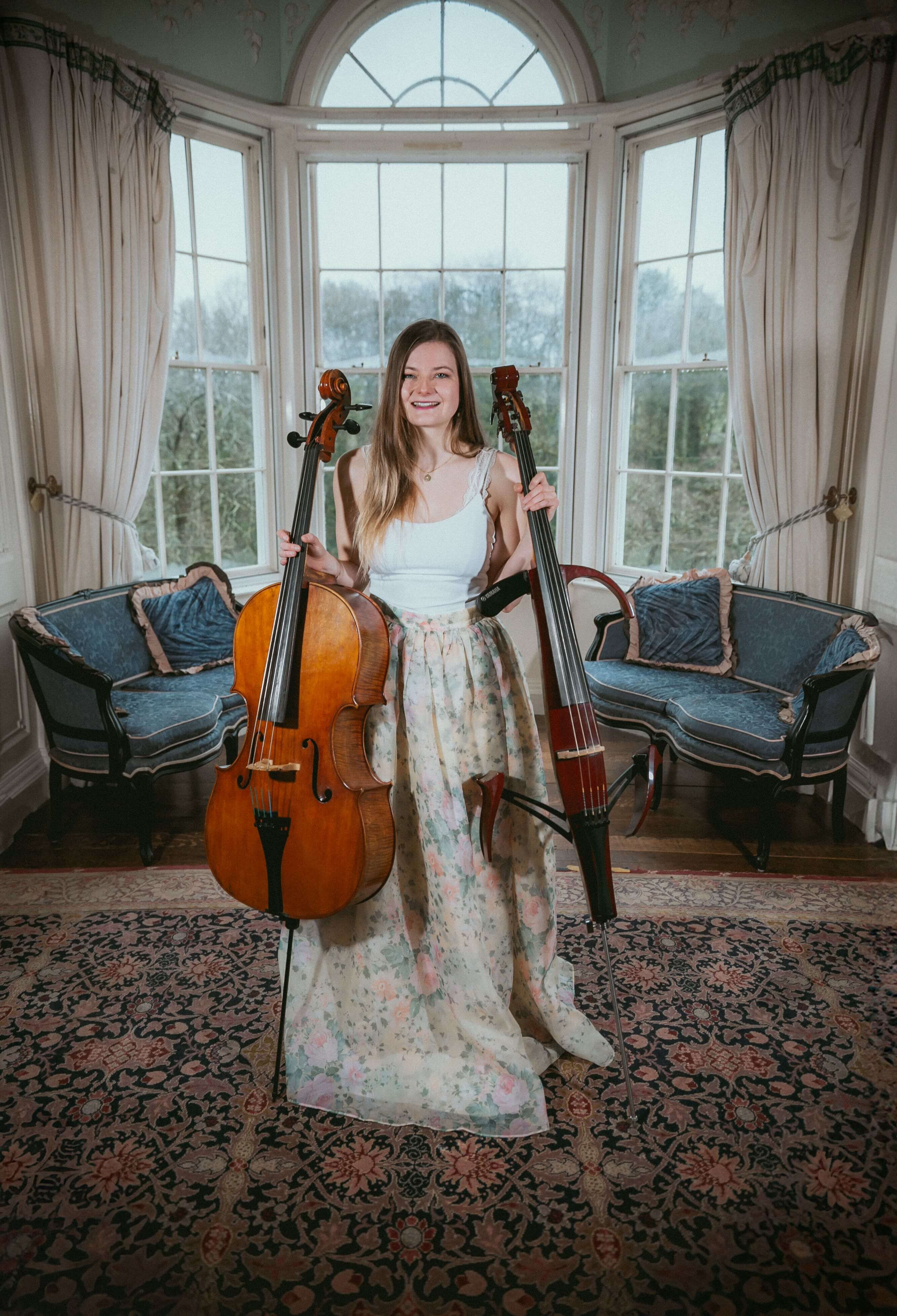 Wedding cellist holding both electric and acoustic cellos